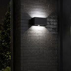 Up and down wall light on textured dark brick at night