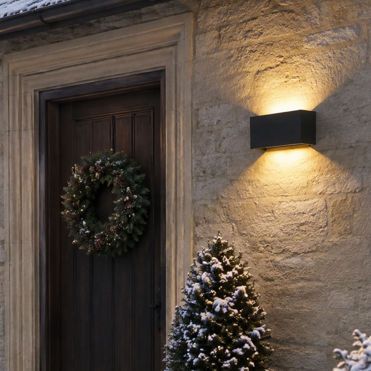 Up and down wall light beside a timber door with a Christmas wreath