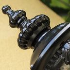 Close-up of the black finial on the domed crown of the lantern