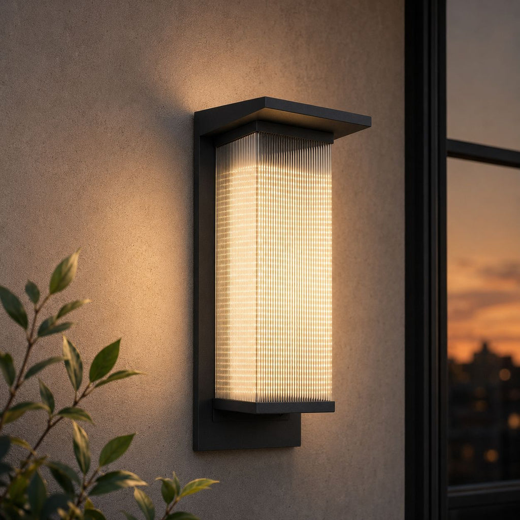 Tall reeded wall light on render beside a window at sunset