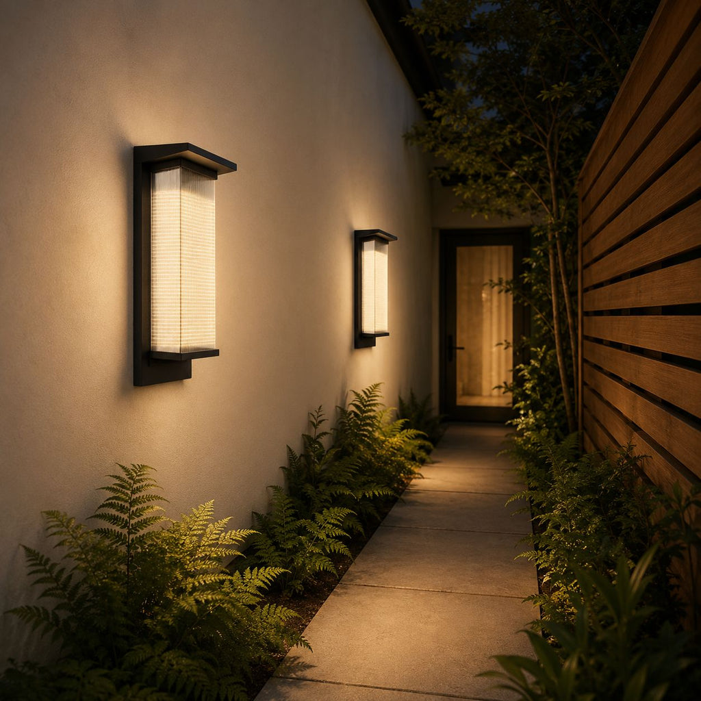 Two reeded wall lights lighting a narrow side passage with ferns