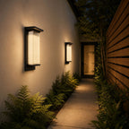 Two reeded wall lights lighting a narrow side passage with ferns