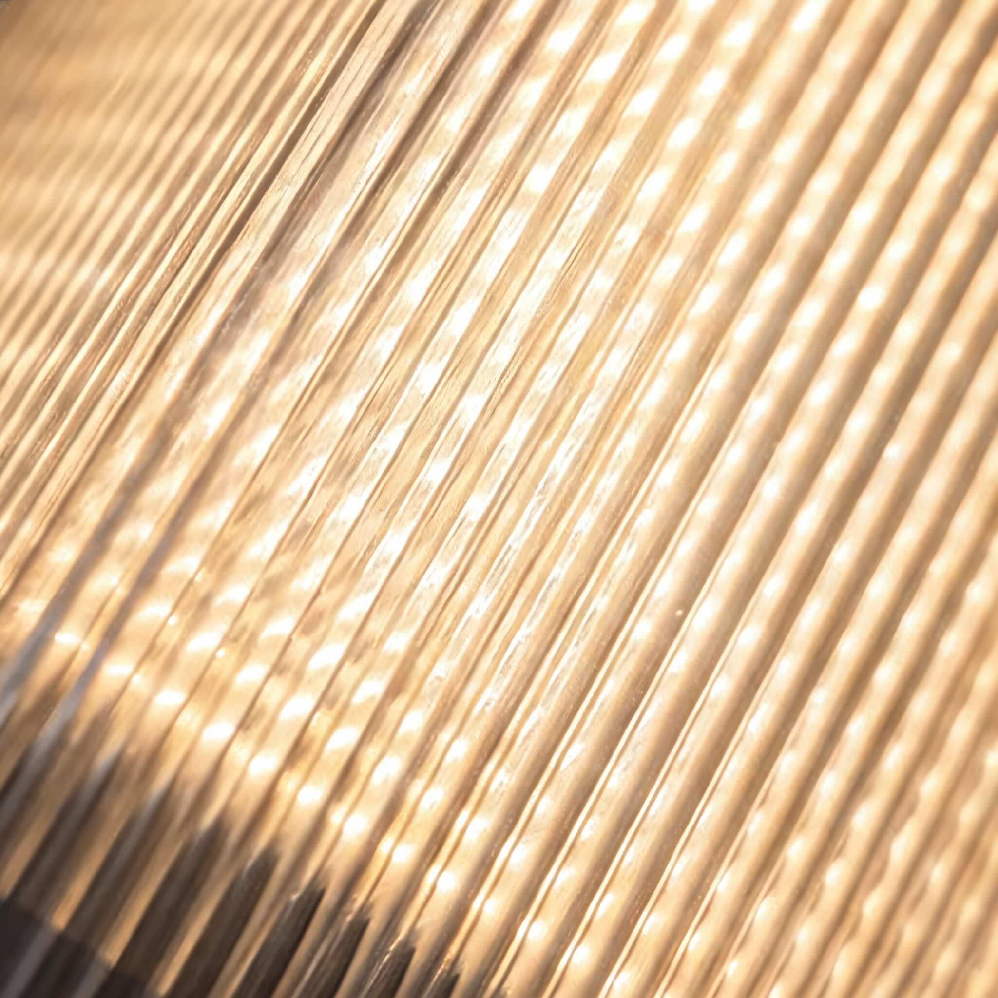 Detail of the vertical reeding catching warm light across the panel
