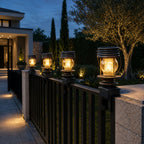 Row of solar lanterns clamped along black railings outside a modern house