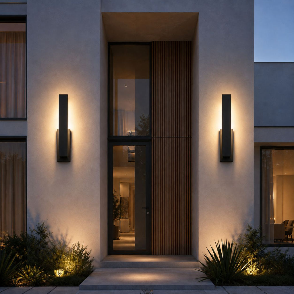 Two slim LED outdoor wall lights flanking a tall glazed entrance on a white rendered house