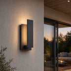 Black LED wall light on a rendered wall beside sliding doors to a patio lounge at dusk