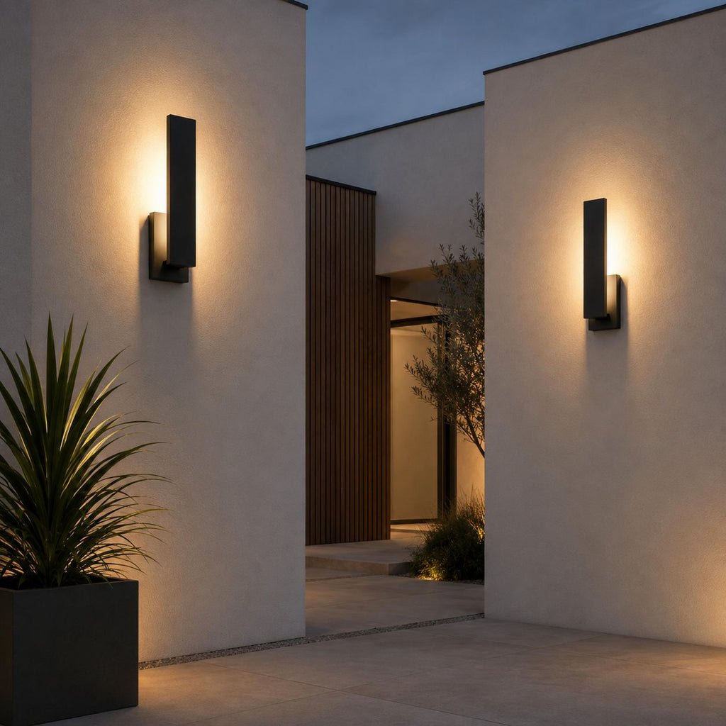 Two slim wall lights on white rendered walls of a modern house with desert planting