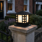 Black slatted post cap light on a stone pier beside a front door and lavender