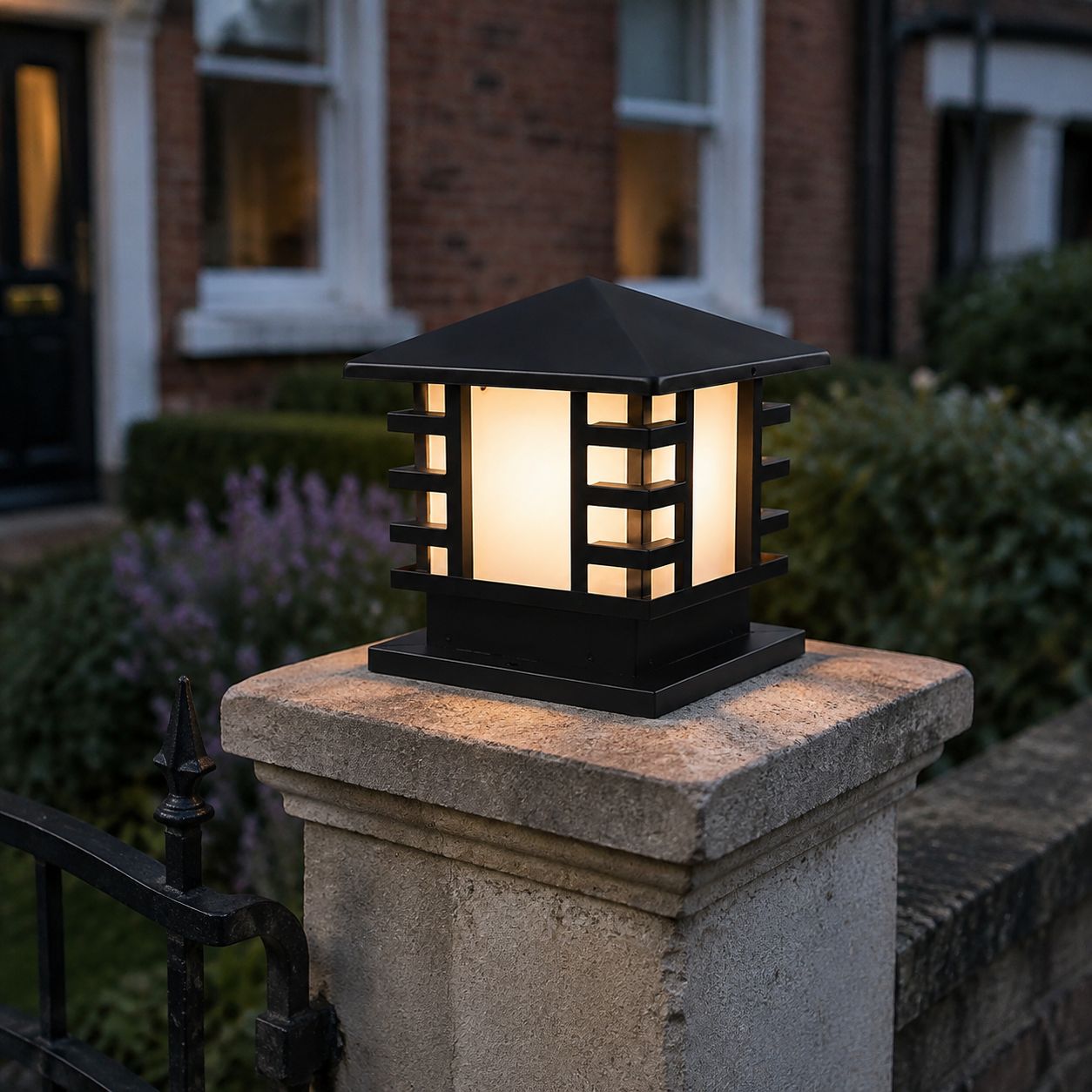 Black slatted post cap light on a stone pier beside a front door and lavender