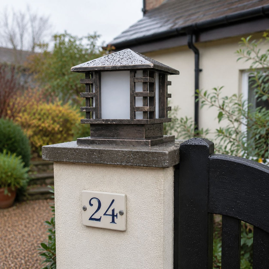 Slatted post cap light on a rendered pier beside a house number twenty four