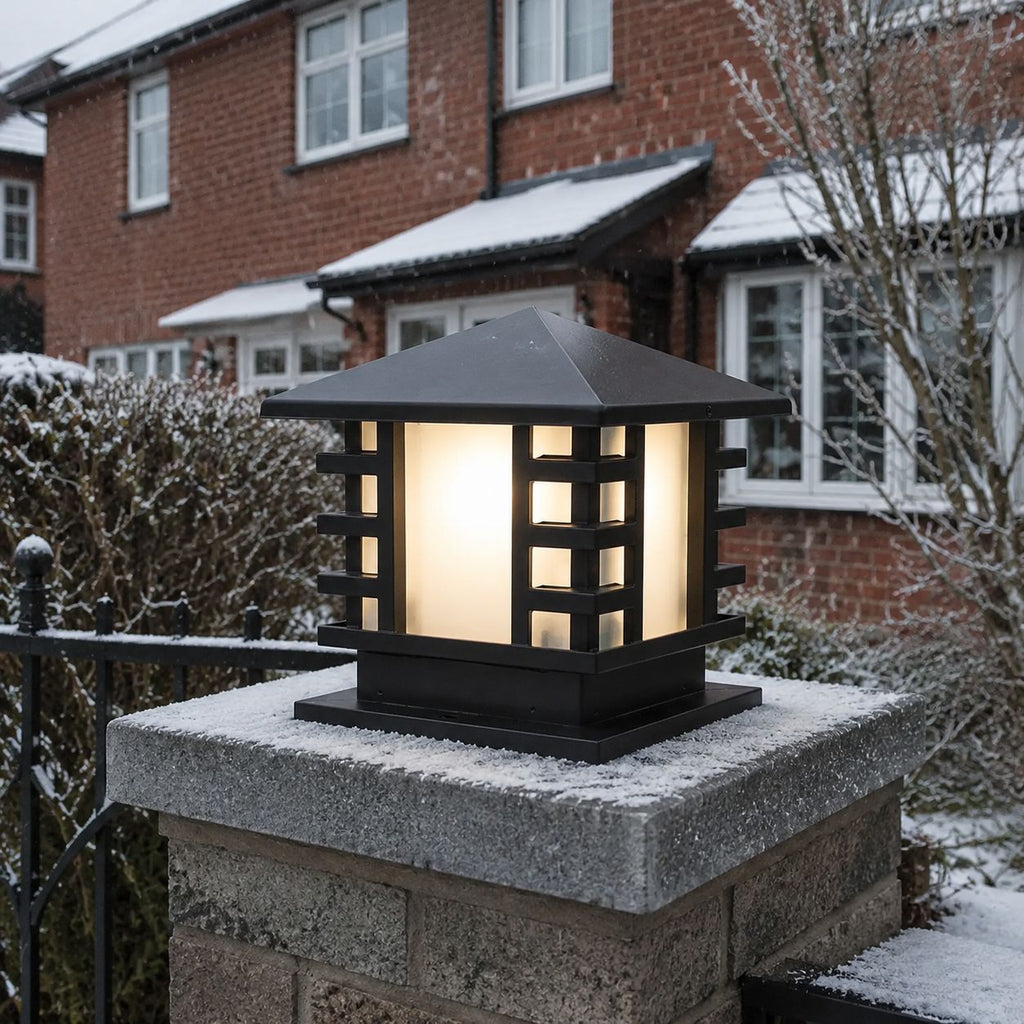 Black slatted post cap light on a snow-covered stone pier