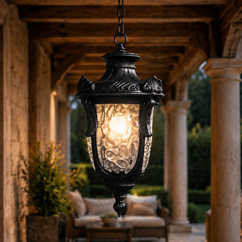 Hammered glass pendant lantern lit under a timber porch beam over garden seating