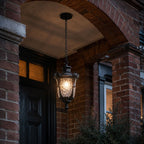 Hammered glass pendant lantern hung in a brick archway above a dark front door
