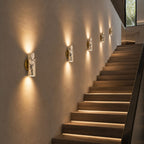 Marble wall lamps along staircase wall with warm ambient architectural lighting