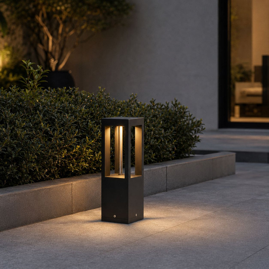 Smallest 30cm garden bollard light set in a raised planter bed with low hedging