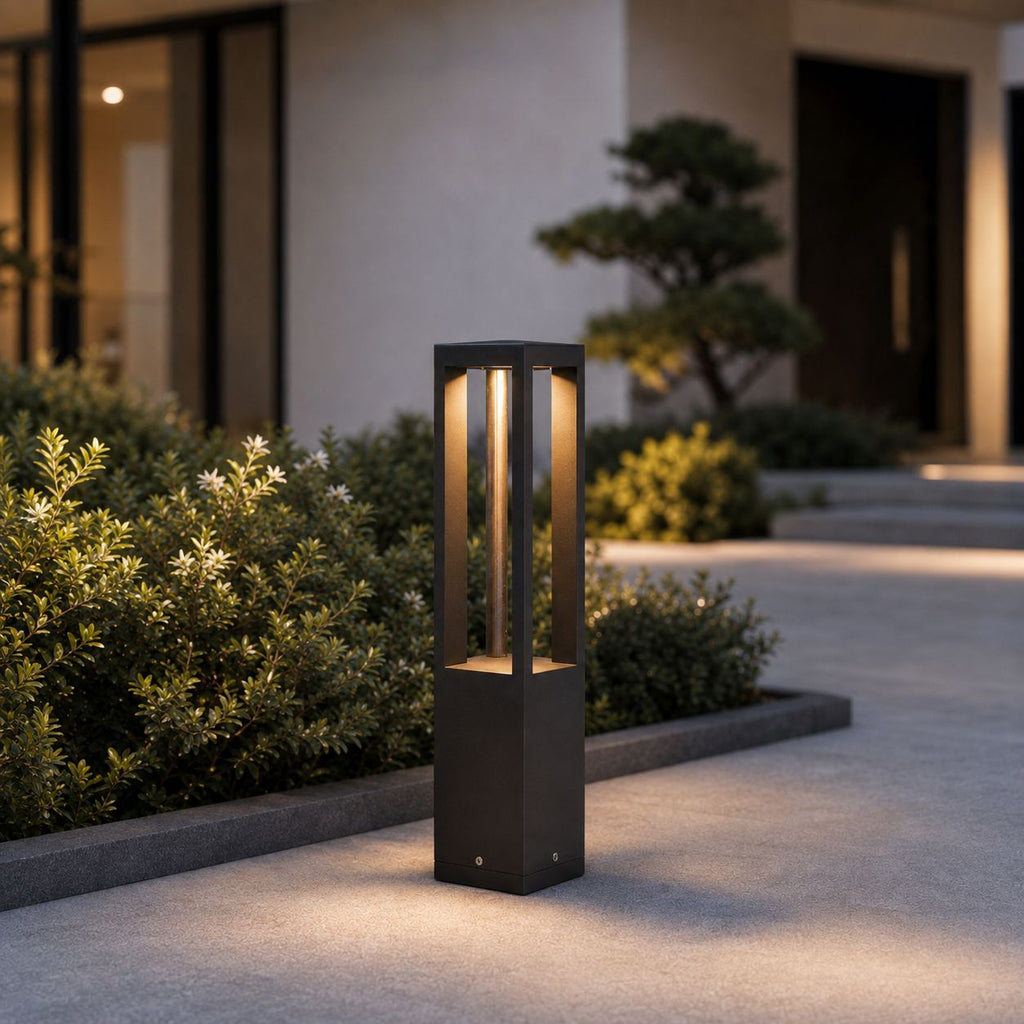 58.5cm bollard light beside clipped shrubs against a modern facade