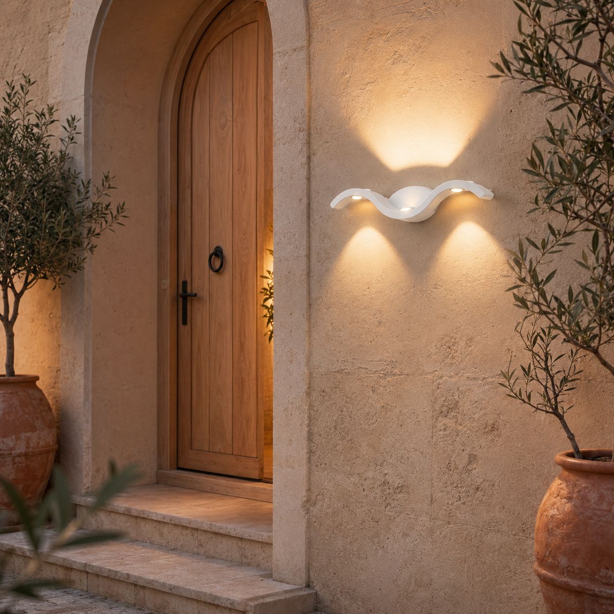 White wave wall light in warm white on render beside a timber front door