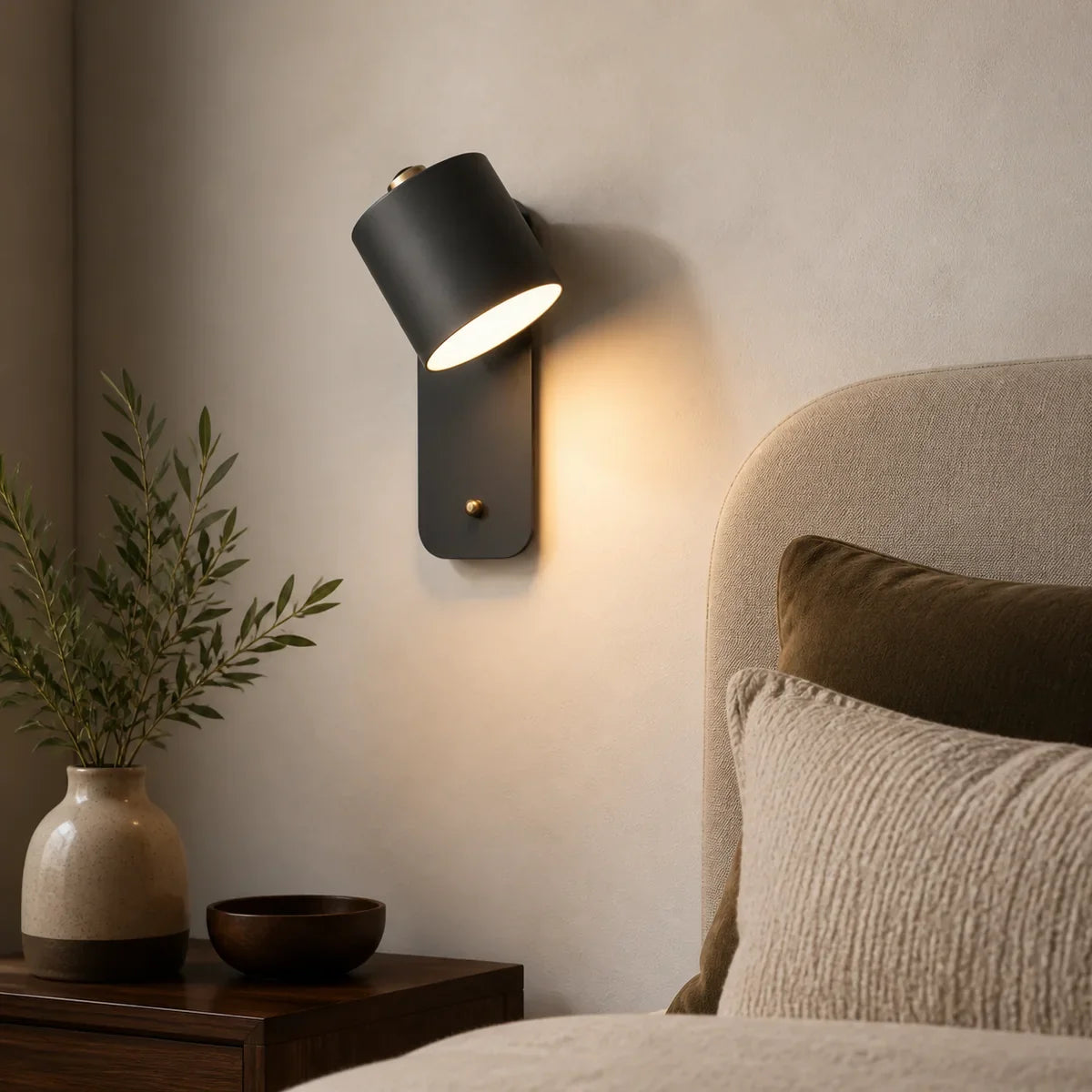 Cylindra black adjustable reading wall light in a close bedroom setting