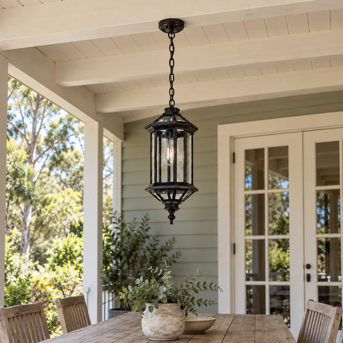 Aurelia clear-glass pendant suspended from a cream timber beam above a verandah dining table.