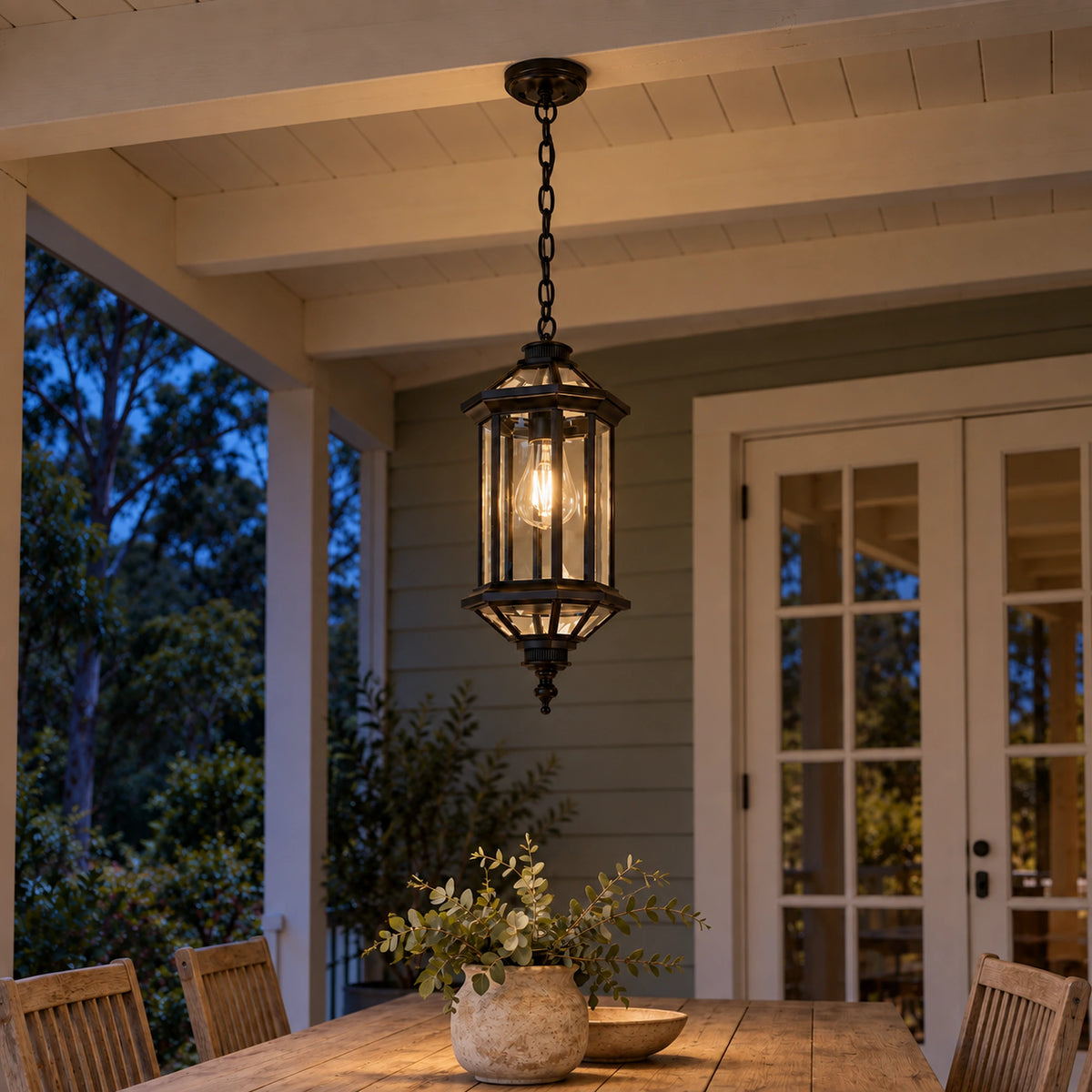 Aurelia pendant glowing warmly above a verandah dining table at dusk.