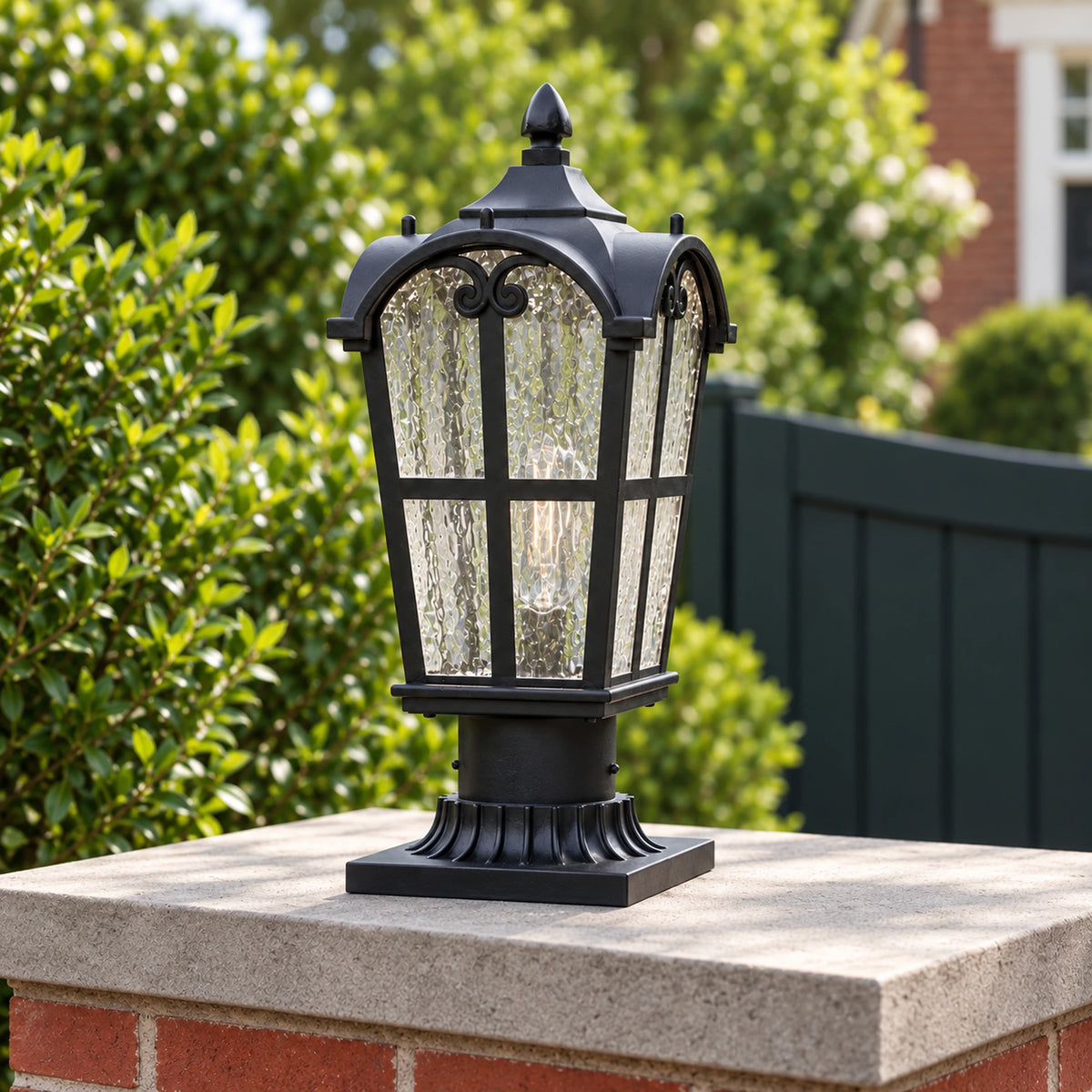 Angled view of a Sentora matte black pillar lantern showing its arched roof, textured glass and flared mounting base.