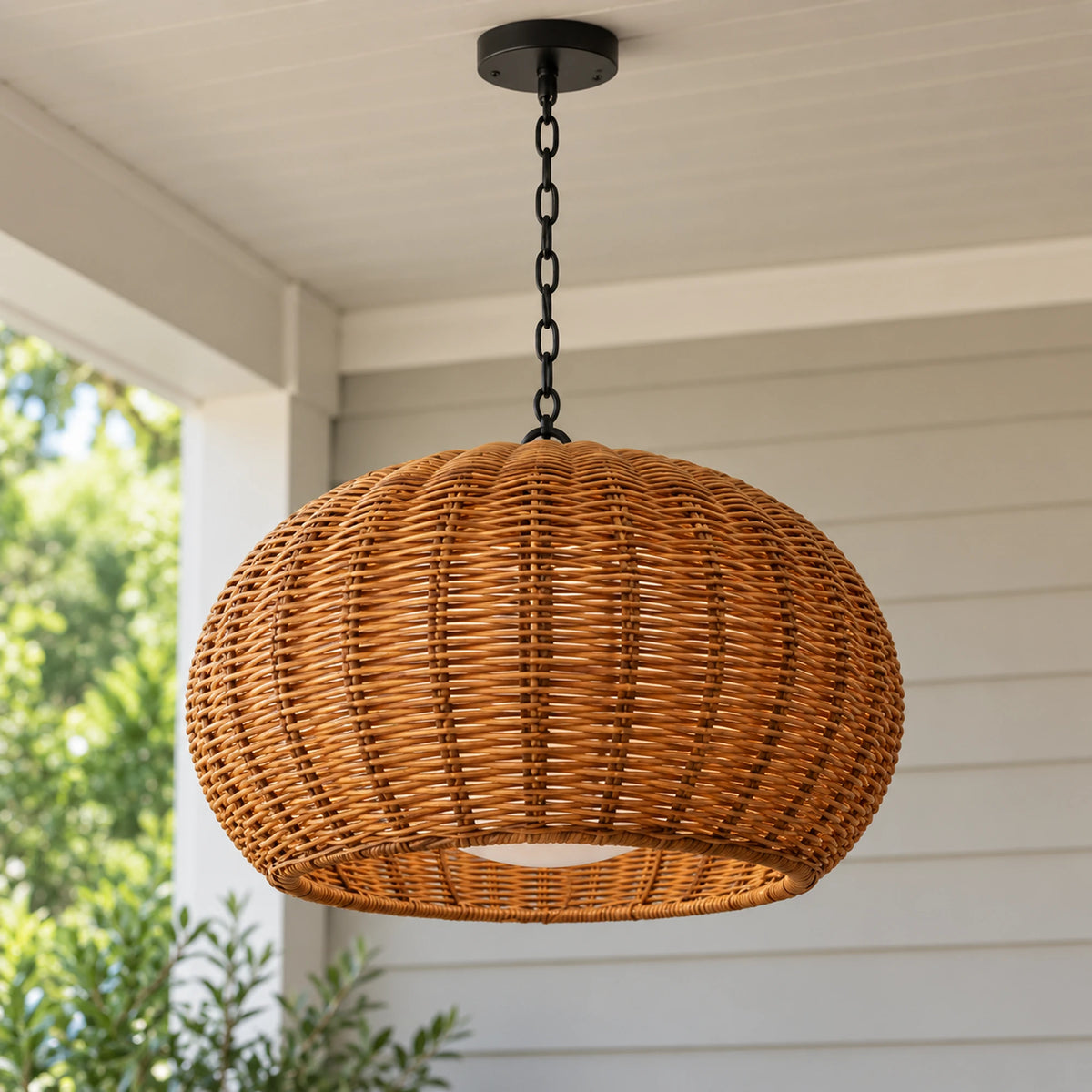 Large Weavora pendant with a deep rounded honey-brown woven shade, black chain and ceiling canopy against pale weatherboards.