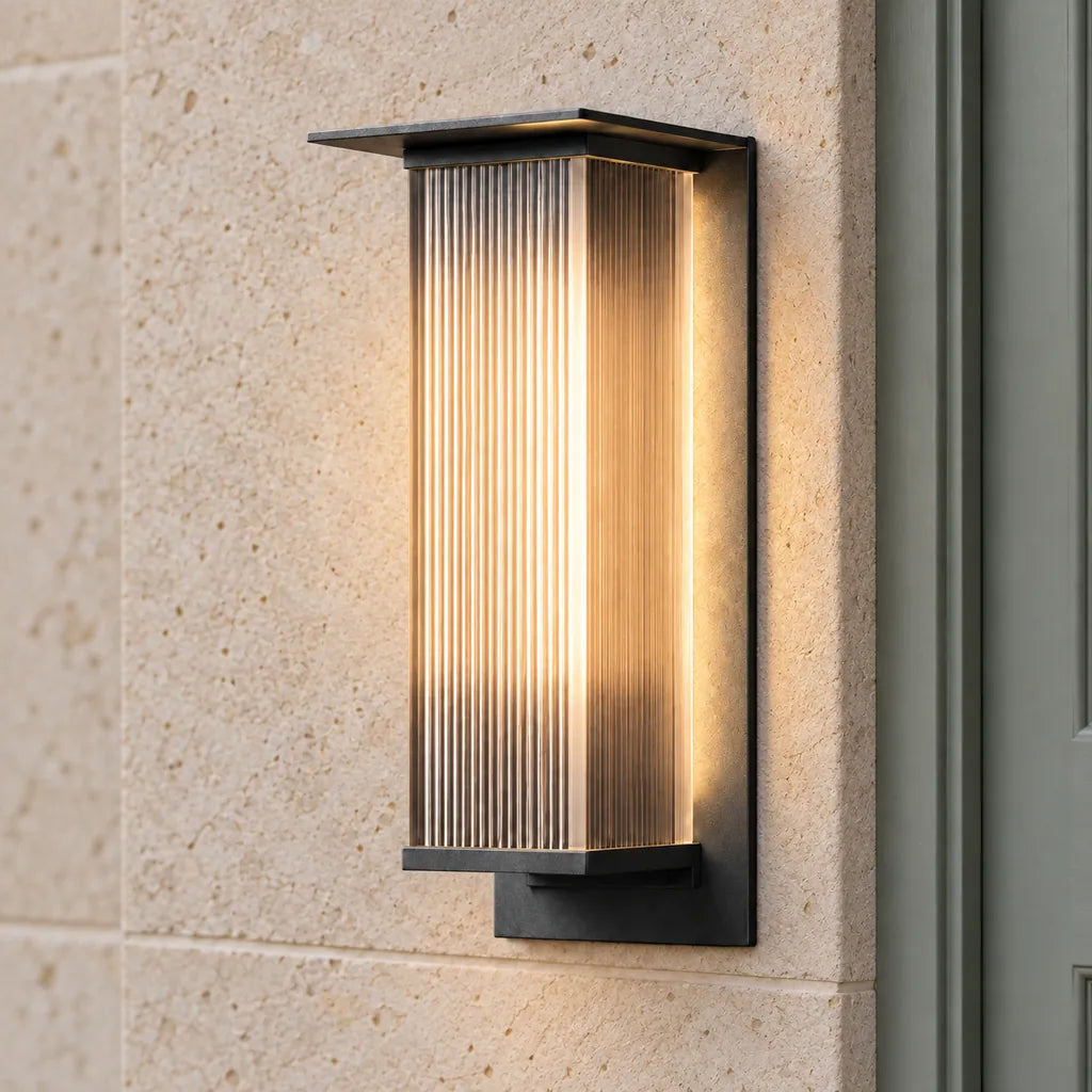 Luminara 36cm black ribbed wall light on a pale stone entrance wall beside a sage grey door