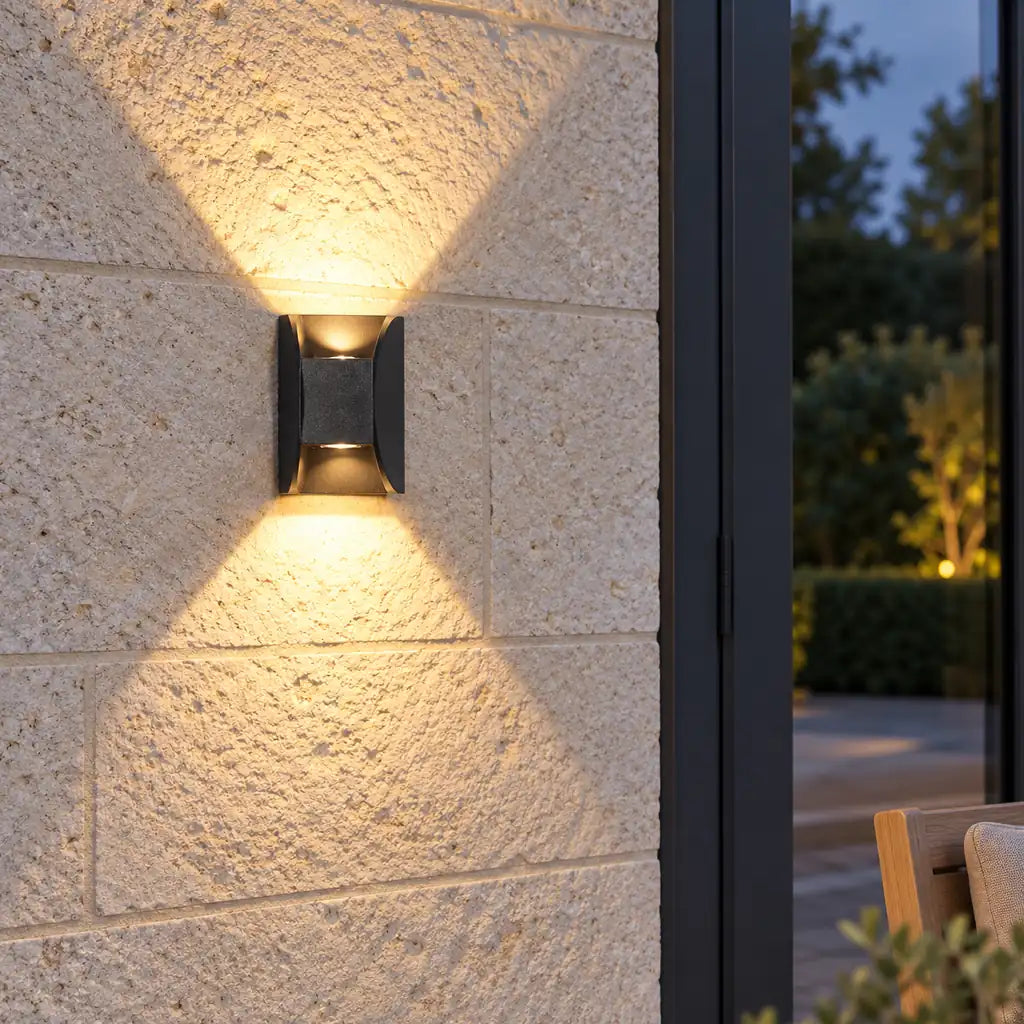 Luminara 12cm up and down wall light beside glazed patio doors on a limestone wall